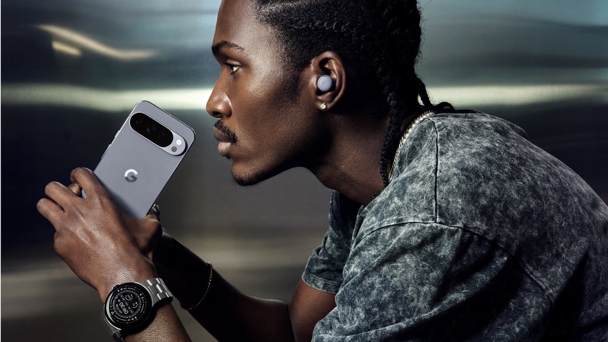 A man holding a Pixel 10 device and wearing a Pixel Watch 4 and the Pixel Buds Pro 2 in Moonstone