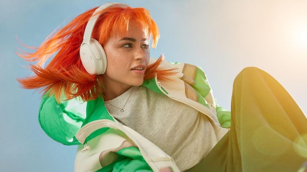 A close-up of a woman wearing Bose QuietComfort headphones.