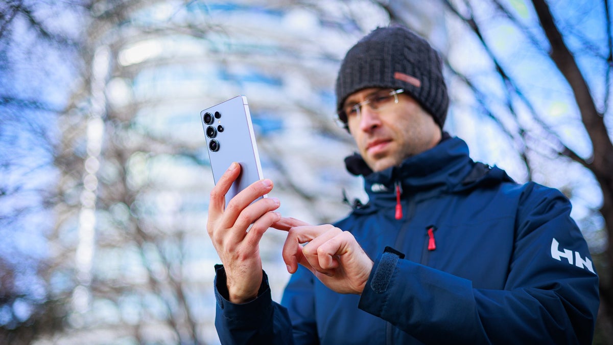 A person holds the Galaxy S25 Ultra in an outdoor environment.
