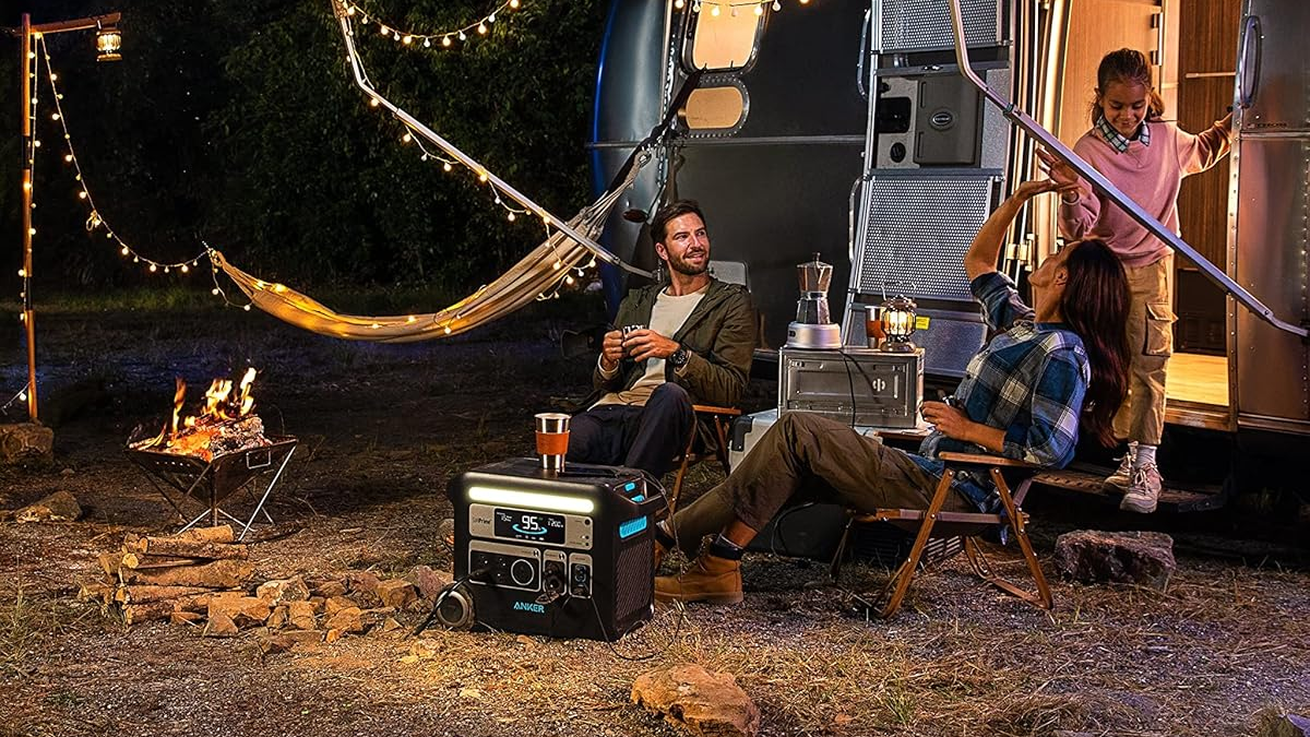 Anker Solix F2000 station placed in an outdoor environment, with lights, people, and an RV in the background.