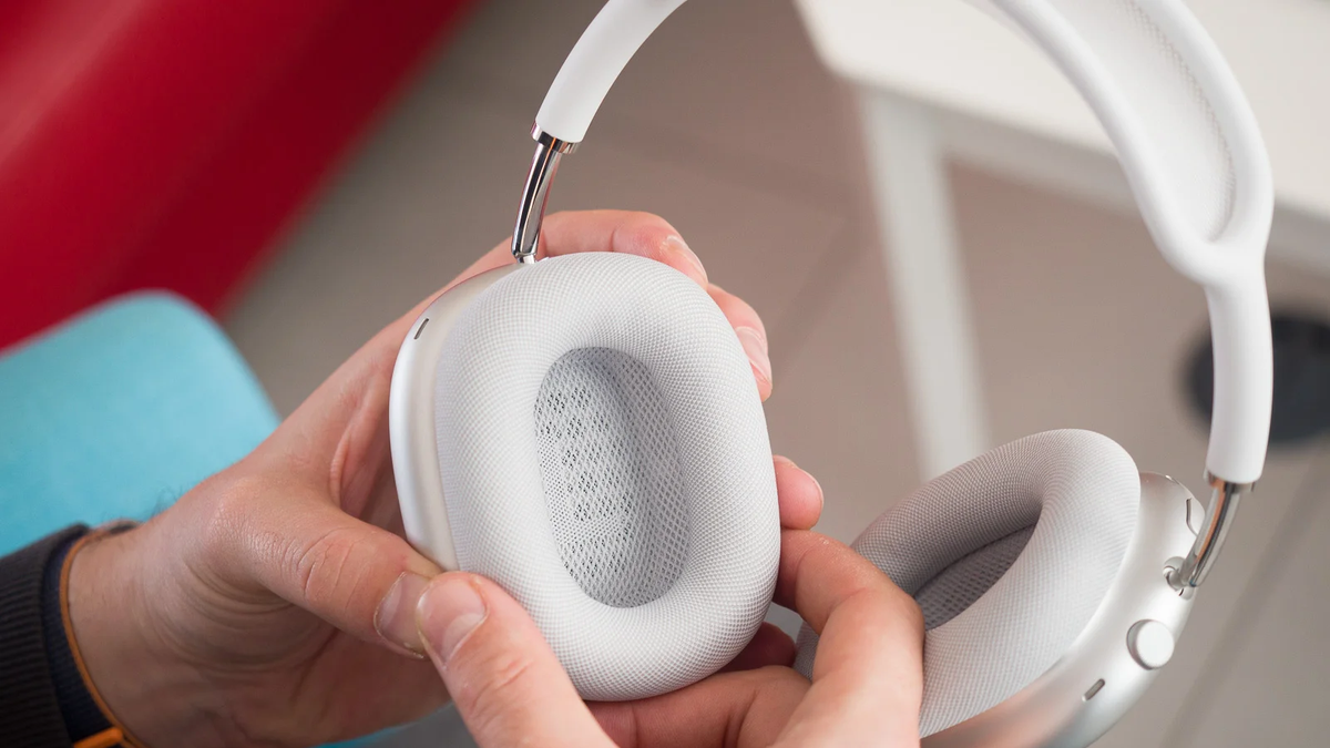 A close-up of the AirPods Max, with a person holding them and showcasing the ear pad design.