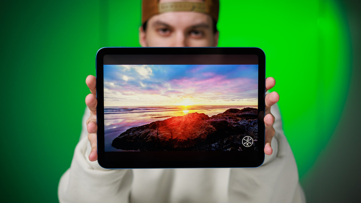 A close-up of a person holding an iPad A16 with both hands.