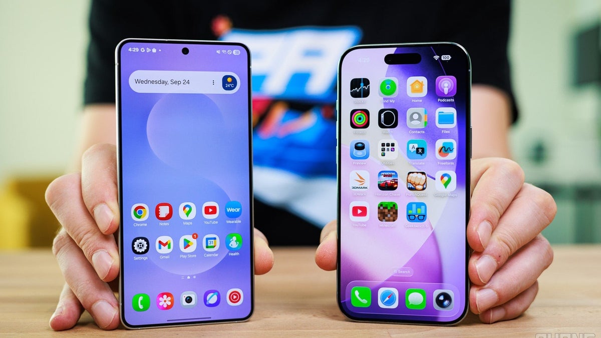 Person holding two smartphones side by side.