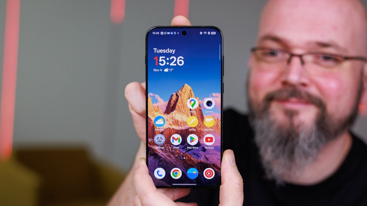 A person holds the OnePlus 15, showing its beautiful display.