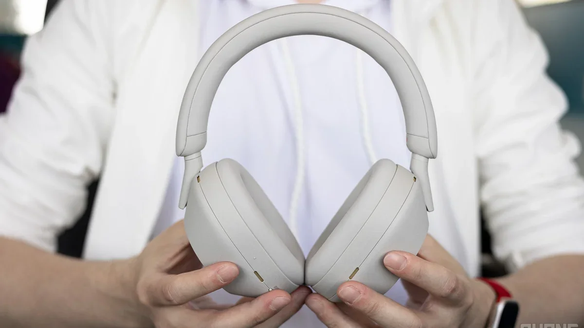A close-up of a person holding a set of Sony WH-1000XM5.