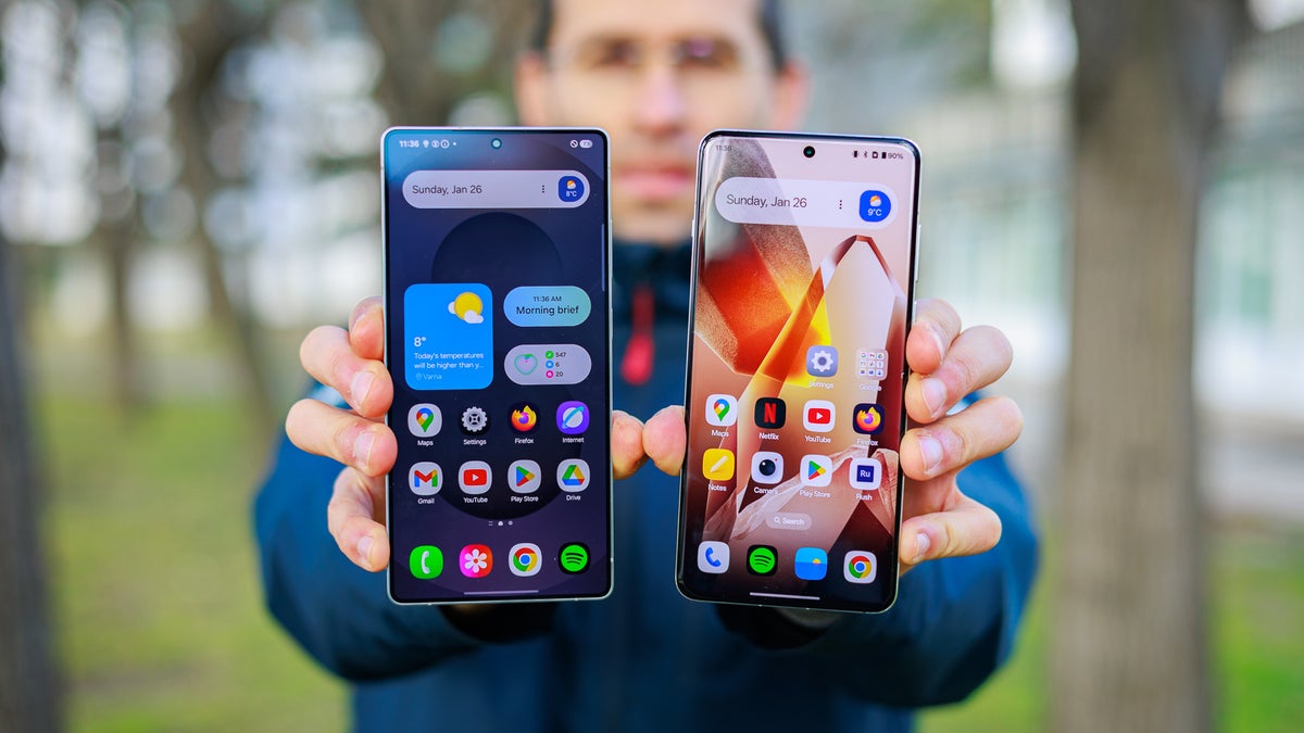 A close-up of a person holding a OnePlus 13 and a Galaxy S25 Ultra.