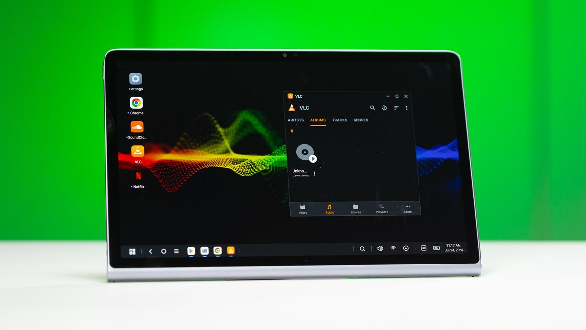 Lenovo Tab Plus on a white table against a green background.
