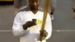 Will.i.am uses his BlackBerry Torch to tweet while holding the Olympic torch in his other hand