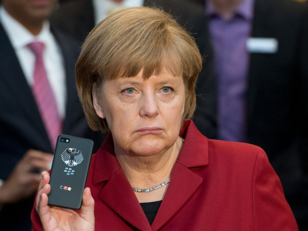 German Chancellor Angela Merkel holds up her secure BlackBerry handset - Germany looking to buy 20,000 BlackBerry 10 phones for its officials?