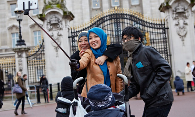 Generic selfie stick being used outside a famous British tourist attraction - The &#039;Selfie Pod&quot; is about to become a red hot holiday gift in the U.K.