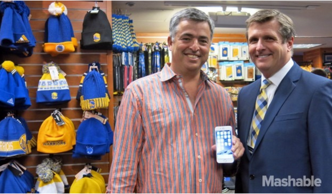 Apple's Eddy Cue (L) poses with Warriors team president Rick Welts and an Apple iPhone 6 - Apple executive Cue helps Apple Pay debut at Oracle Arena
