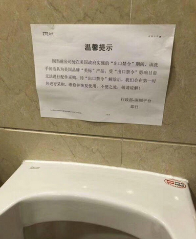 Sign above broken urinal at ZTE facility says that the company must wait for the U.S. export ban to be lifted before it can be fixed - ZTE remains in limbo, caught between deal with White House and possible legislation