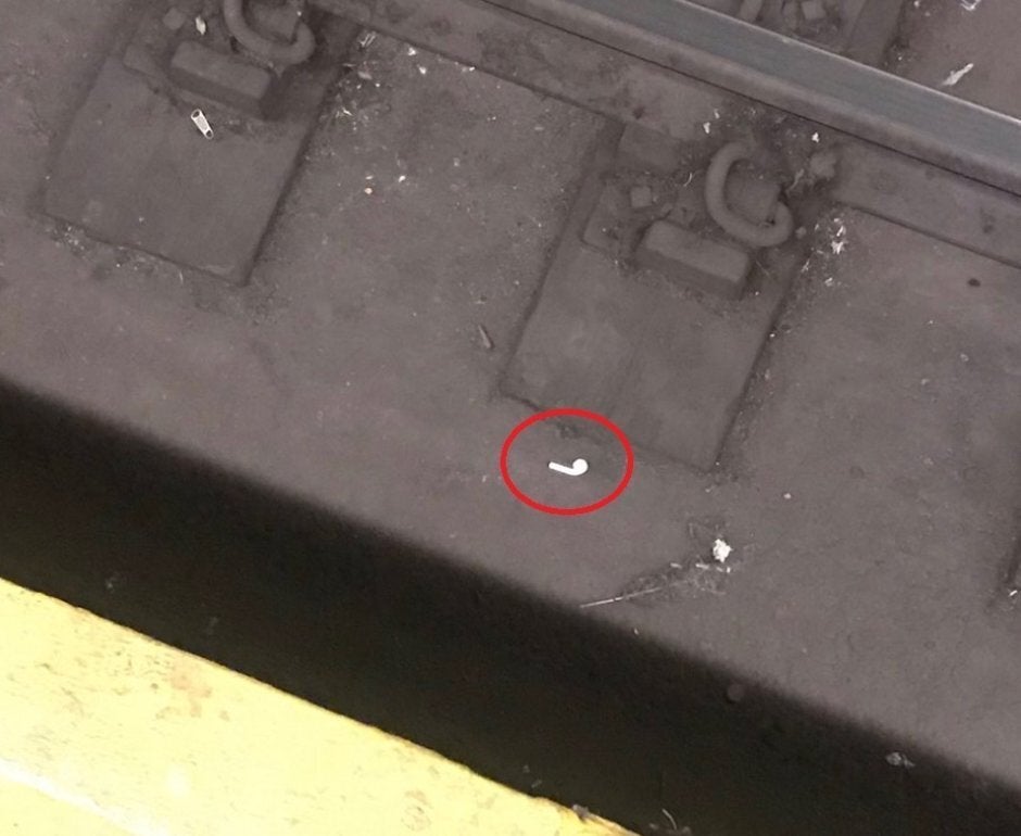 An Apple AirPod sits next to a subway rail before getting rescued - Lost AirPods are becoming a problem in New York City