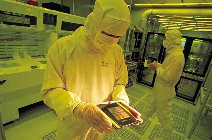Empleado de TSMC revisando cosas en una fábrica: para aliviar la escasez mundial de chips, TSMC considera construir una nueva fábrica en Singapur
