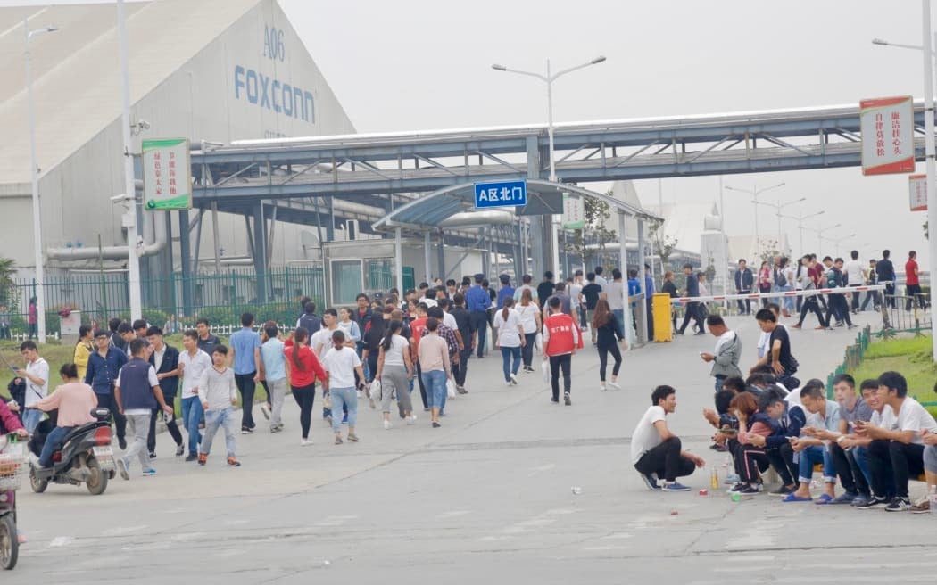 Foxconn workers in Zhengzhou leaving the campus last month after the government instituted a COVID crackdown - Foxconn investing in other countries helps Apple diversify iPhone production out of China