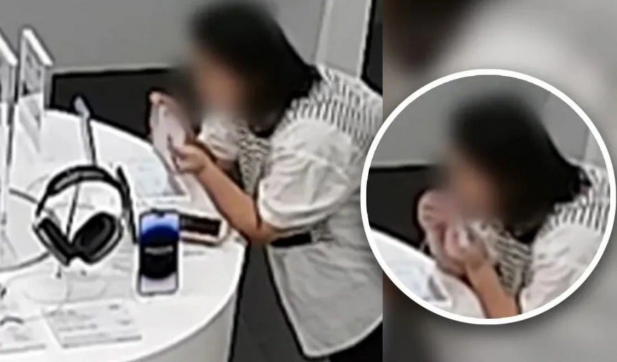 Apple Store security camera captures a woman biting the anti-theft cable to steal an iPhone 14 Plus. Image credit-SCMP - Apple Store thief steals iPhone 14 Plus using a unique plan before getting nabbed