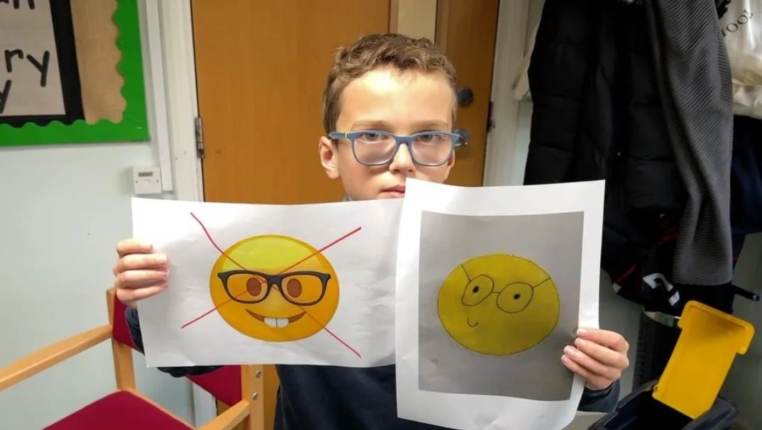 Teddy mostra o atual emoji de rosto de nerd ofensivo com seu próprio emoji de gênio substituto à direita.  Crédito da imagem BBC – Teddy, de 10 anos, inicia petição para que a Apple mude o emoji ofensivo