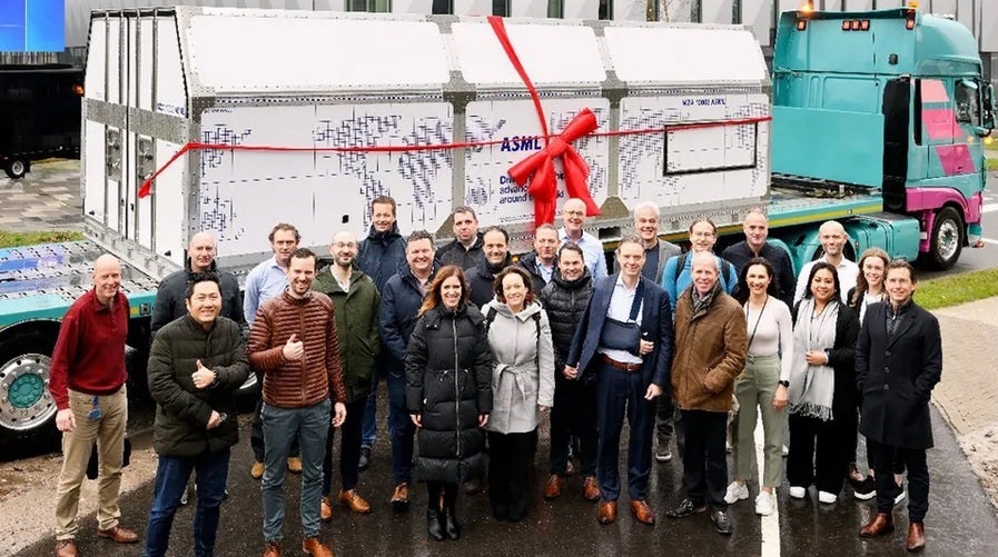 ASML employees stand in front of a container containing the unassembled High-NA EUV machine heading to Intel - A $400 million machine ships to Intel today kicking off a new era of powerful chips