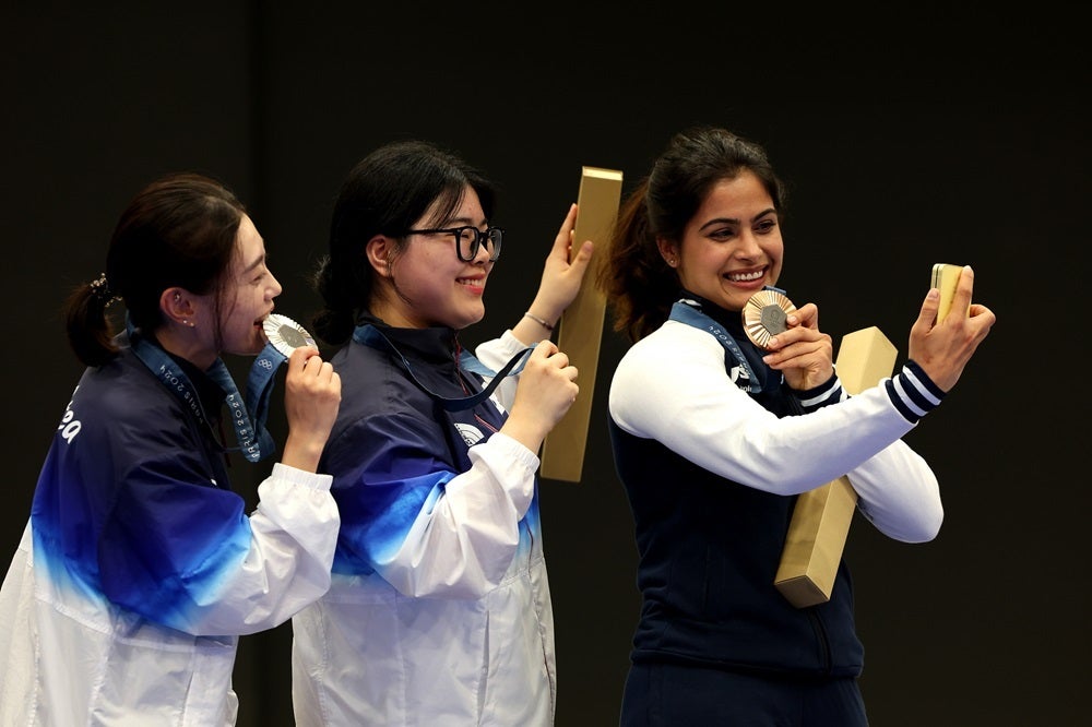 From left – Silver medalist Yeji Kim and gold medalist Ye Jin Oh of Team Republic of Korea and bronze medalist Manu Bhaker of Team India pose for their Victory Selfie after the women’s 10m air pistol shooting competition. | Photo by Charles McQuillan, Getty Images - What is the Galaxy Victory Selfie, and why it&#039;s so darn hard to take one (Gallery)