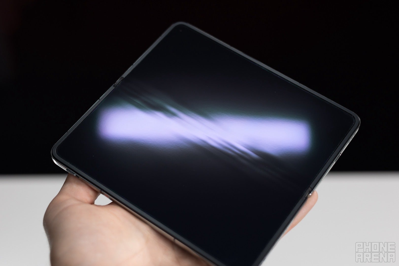 An image of the OnePlus Open held up showcasing its display with a beam of light across it