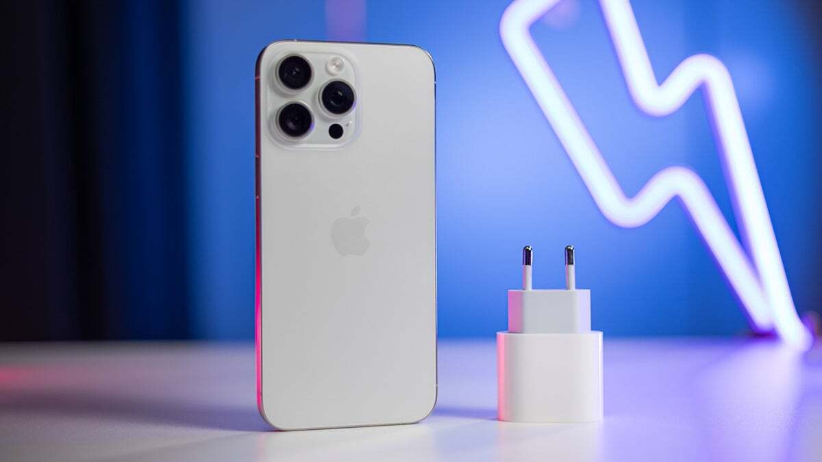 An iPhone and a charging brick on blue neon background.