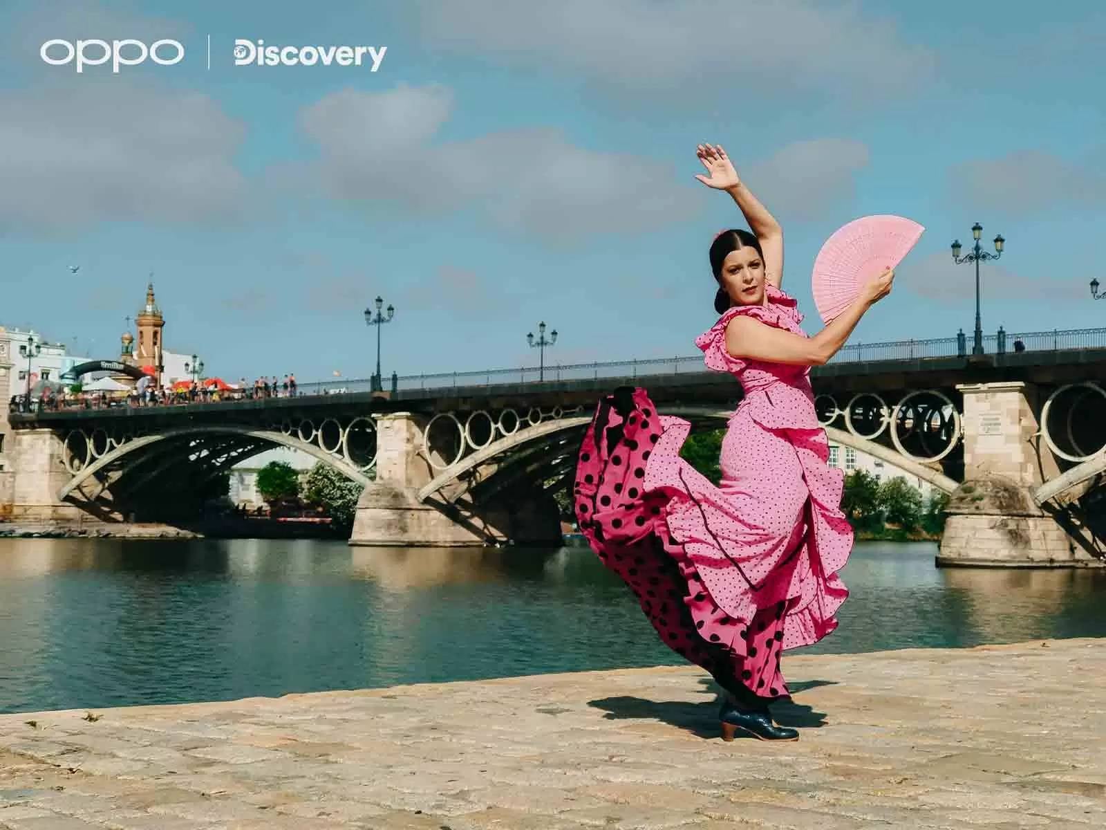 A female flamenco dancer in a pink dress next to a river.