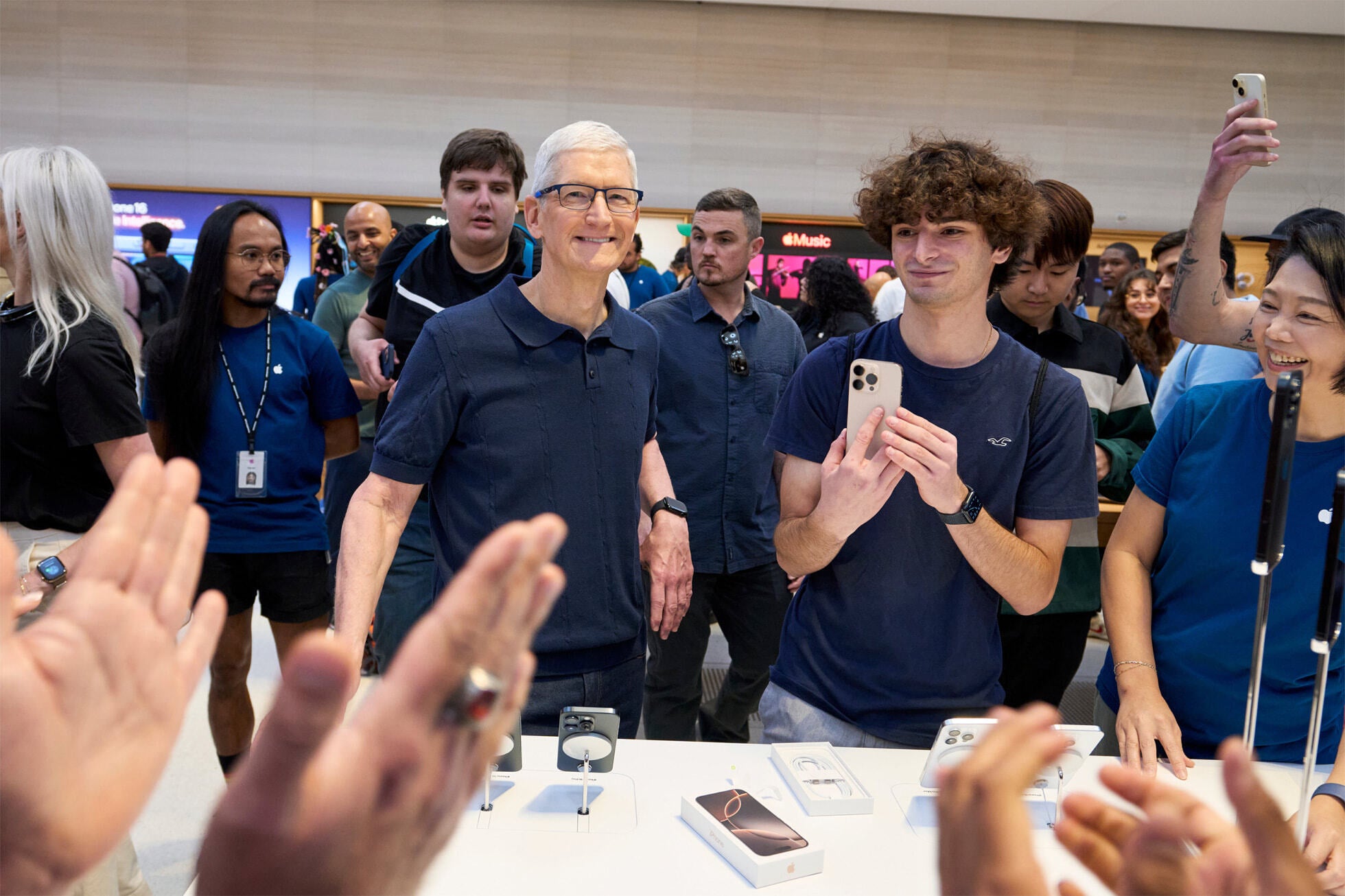 Apple CEO Tim Cook (L) watching as another iPhone 16 model is sold. Image credit-Apple - Apple Stores arund the globe were crowded last Friday as the iPhone 16 line was released