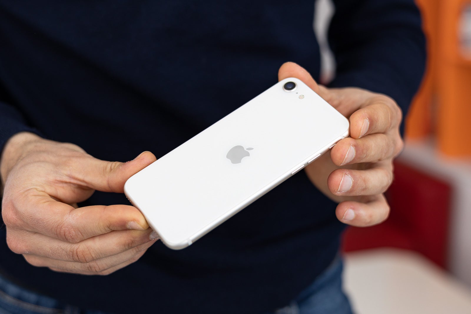 An image of a person holding an iPhone SE