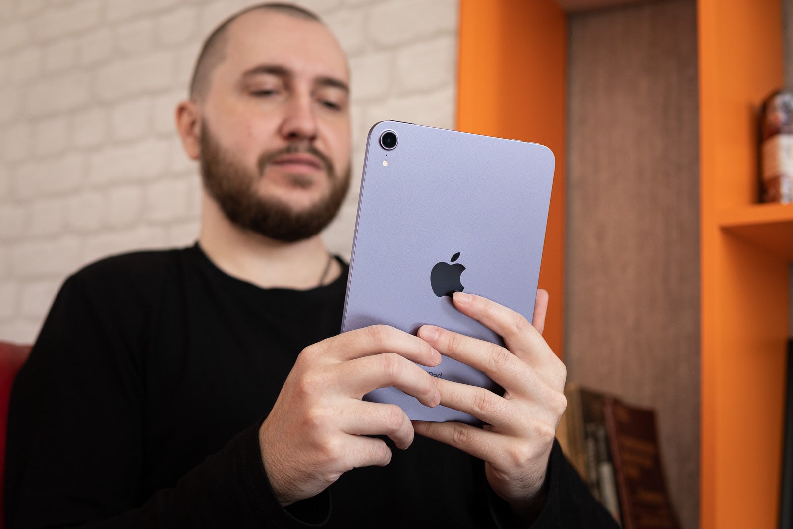 An image of a person holding and looking at an iPad Mini