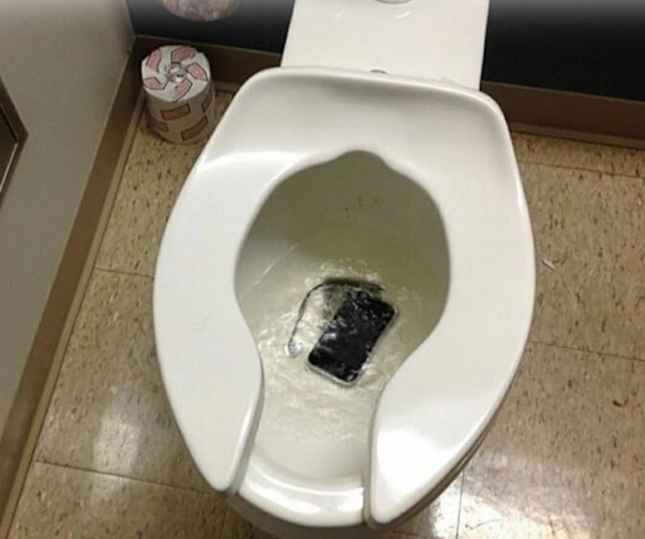 A phone has dropped into a toilet bowl.