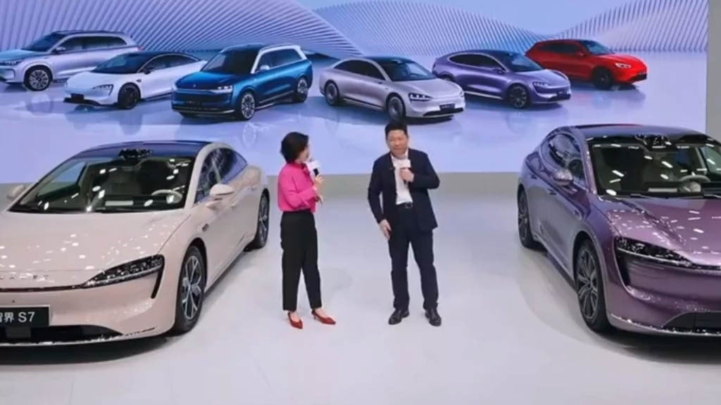 At the Guangzhou Auto Show 2024, Yu put his hand over his pocket to hide the Mate 70 flagship phone. | Image credit-Weibo - Huawei Chairman covers his pocket so unannounced Mate 70 won't leak