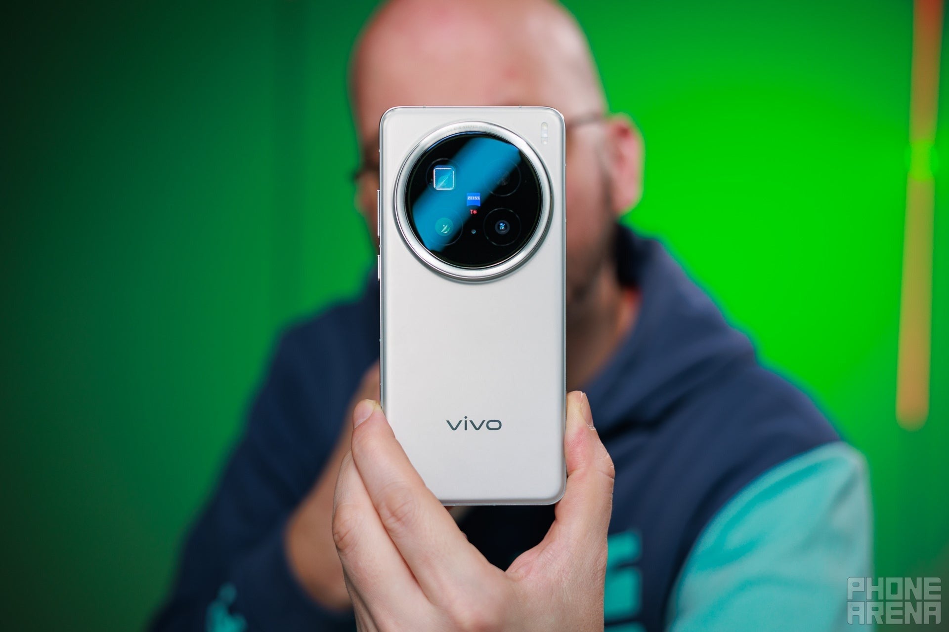 A bald man showing the Vivo X200 Pro&amp;#039;s back to the camera.