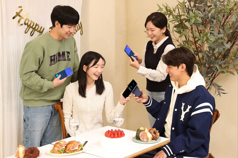 Four people with their smartphones sitting together. 