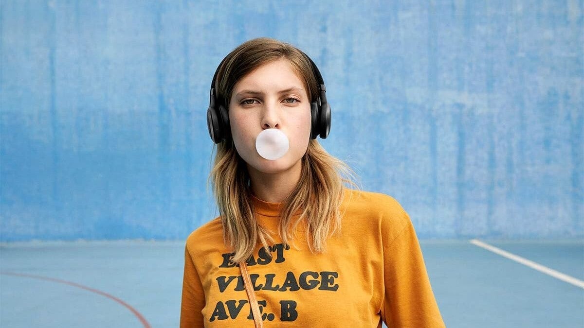 A close-up of a woman wearing a set of JBL headphones.