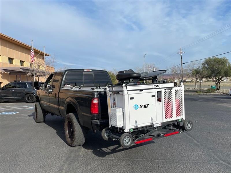 A black pickup truck with an AT&amp;amp;T mobile cell tower unit attached to the back.