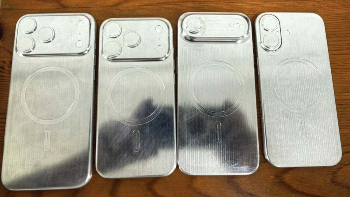 A photo of four metal molds for iPhone cases, showing different camera cutouts and MagSafe ring imprints.