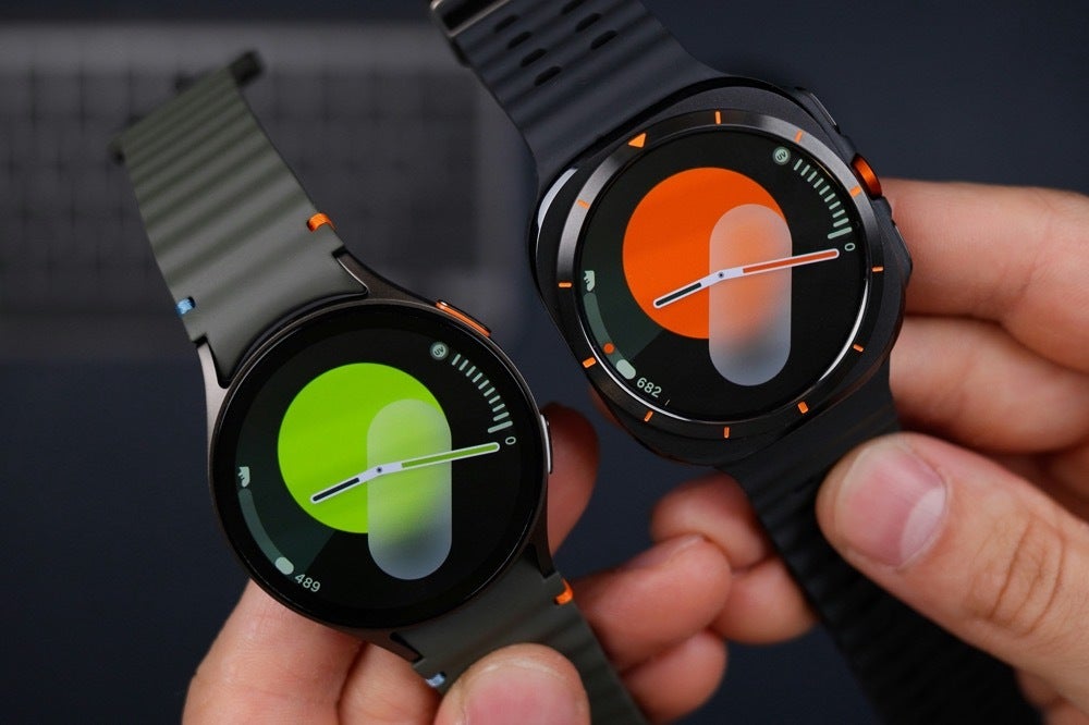 Image of a person holding two Samsung smartwatches