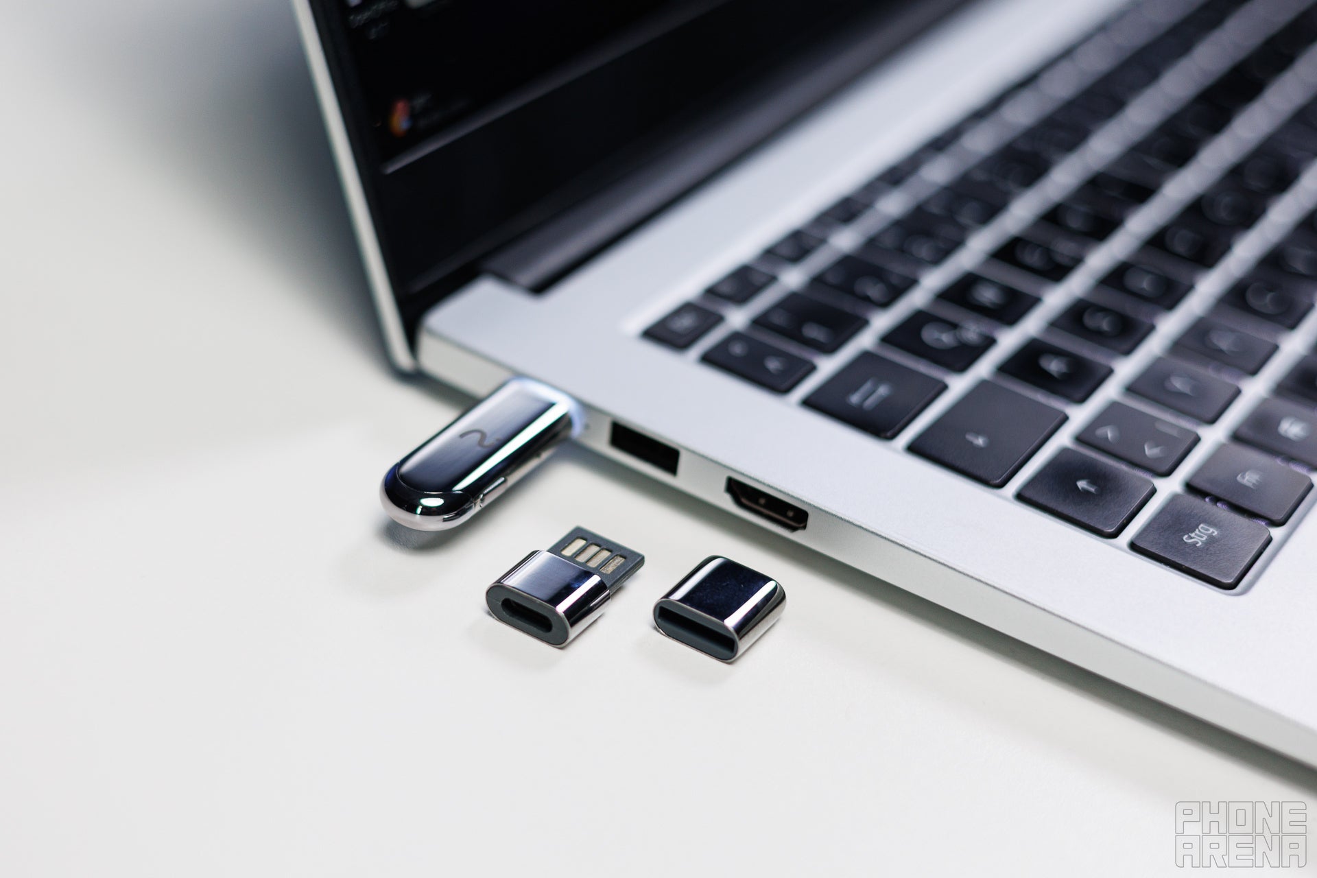 Viaim NoteKit plugged into a laptop, the protective cap and USB adaptor are laying close as a showcase
