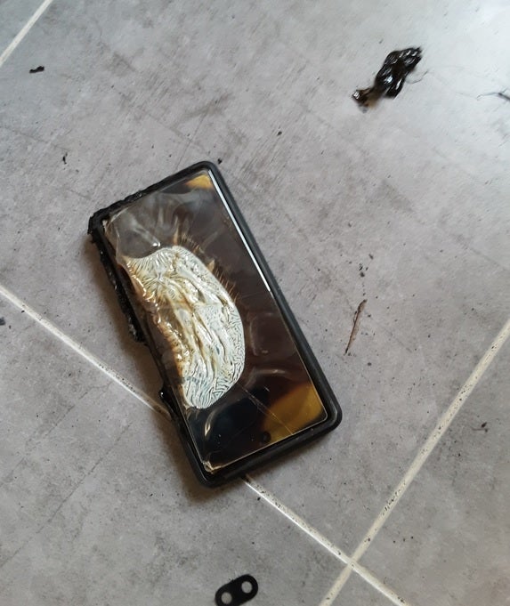 The burnt Pixel 6a is the subject of a photograph.