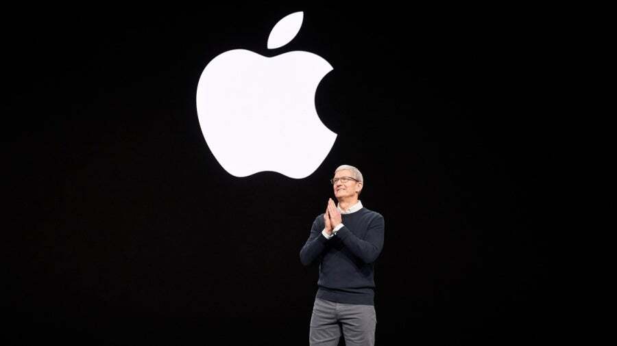 Tim Cook, Apple CEO, stands in front of the iconic apple logo.