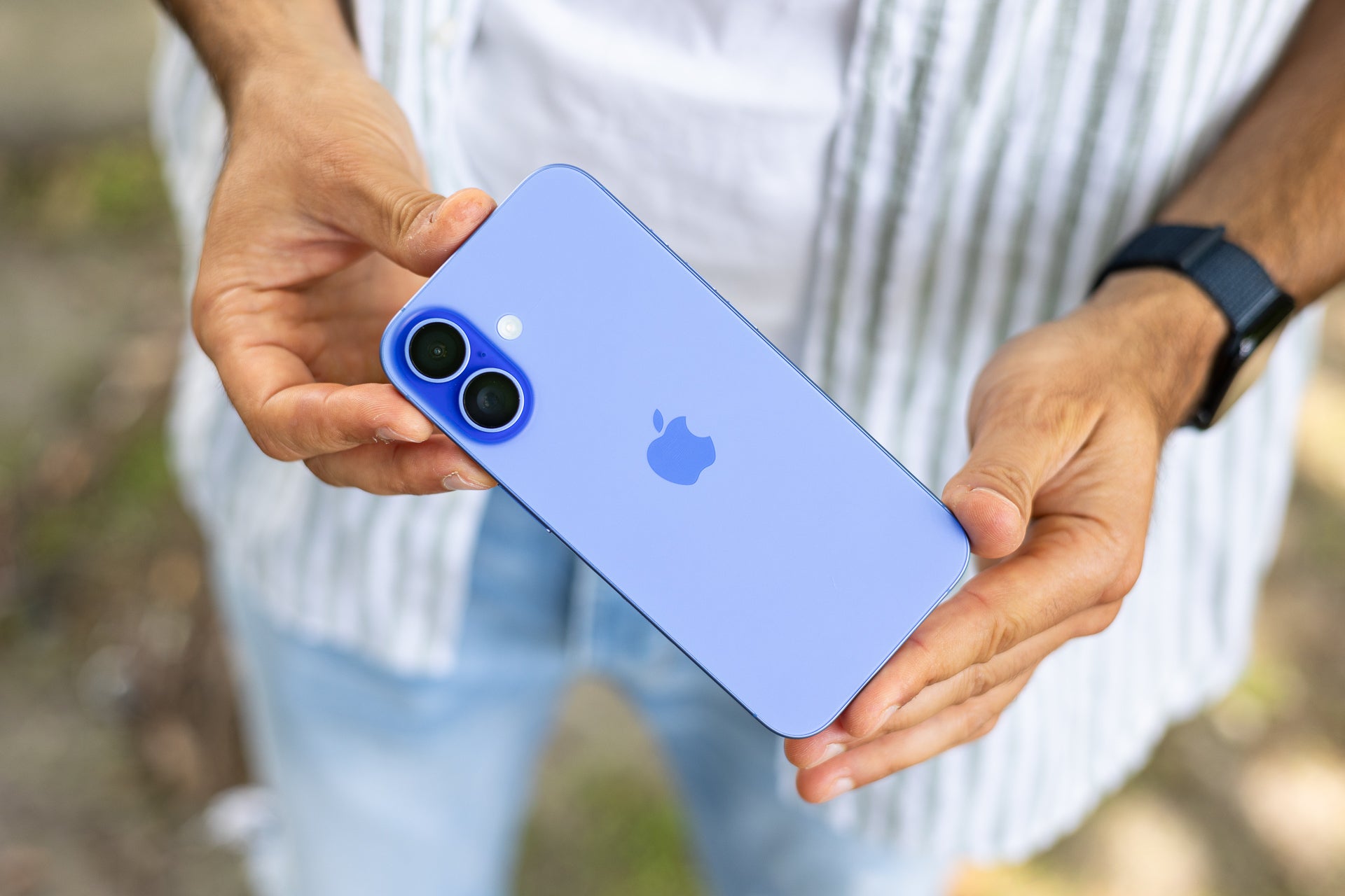 iPhone 16 held in hands.