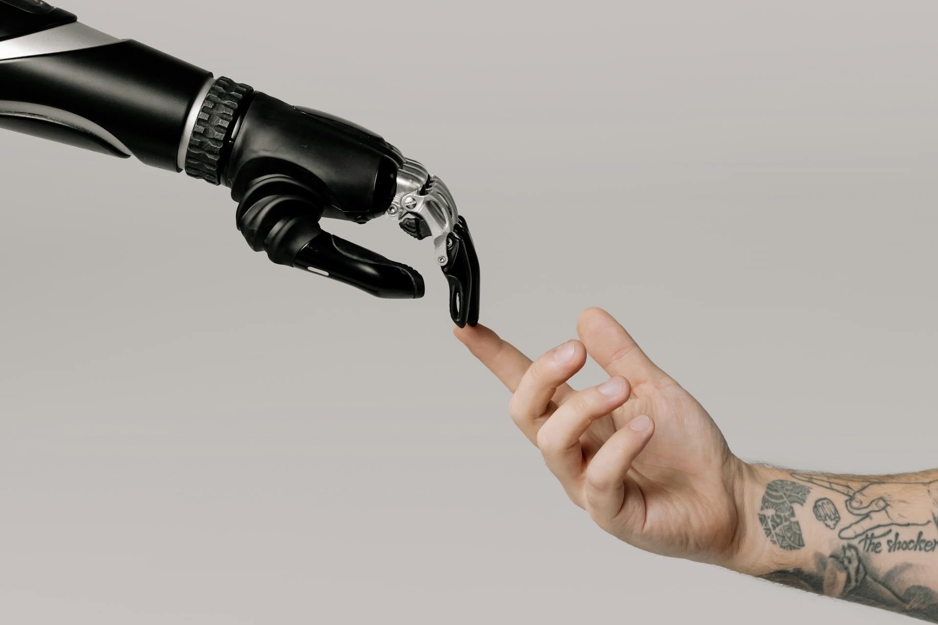 Image of bionic and human hand touching fingers