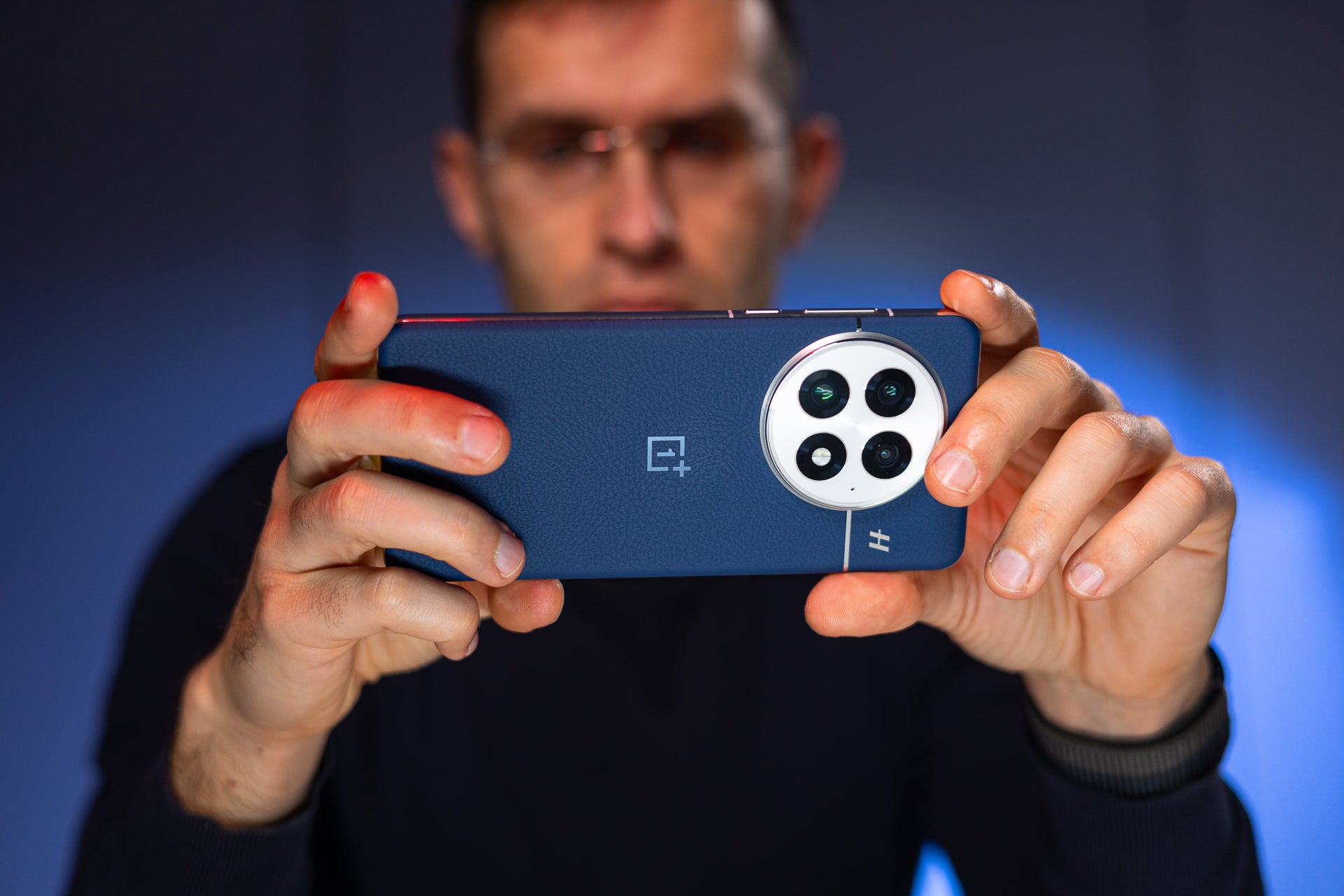 A man holding the OnePlus 13.