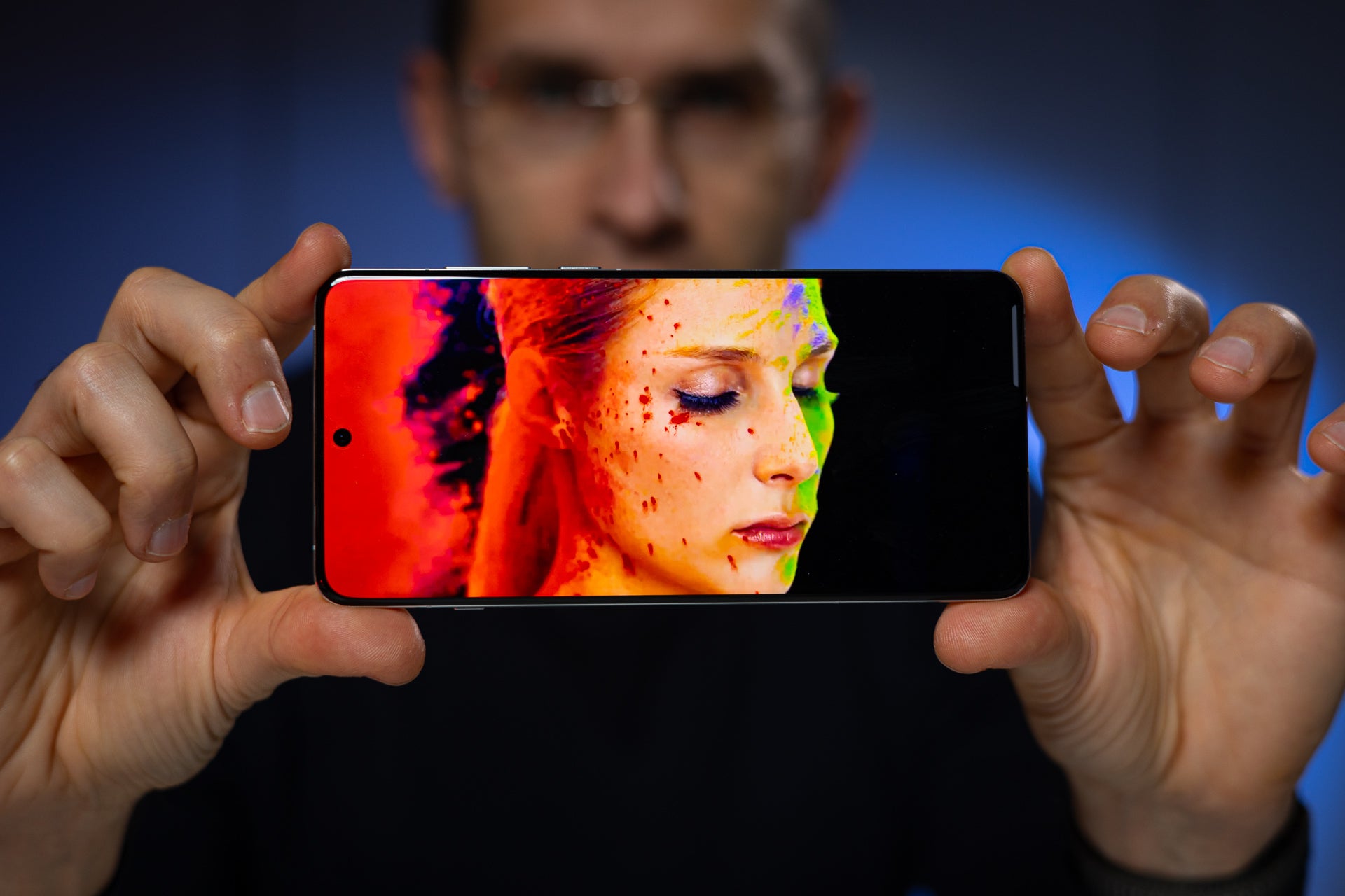A man holding the OnePlus 13.