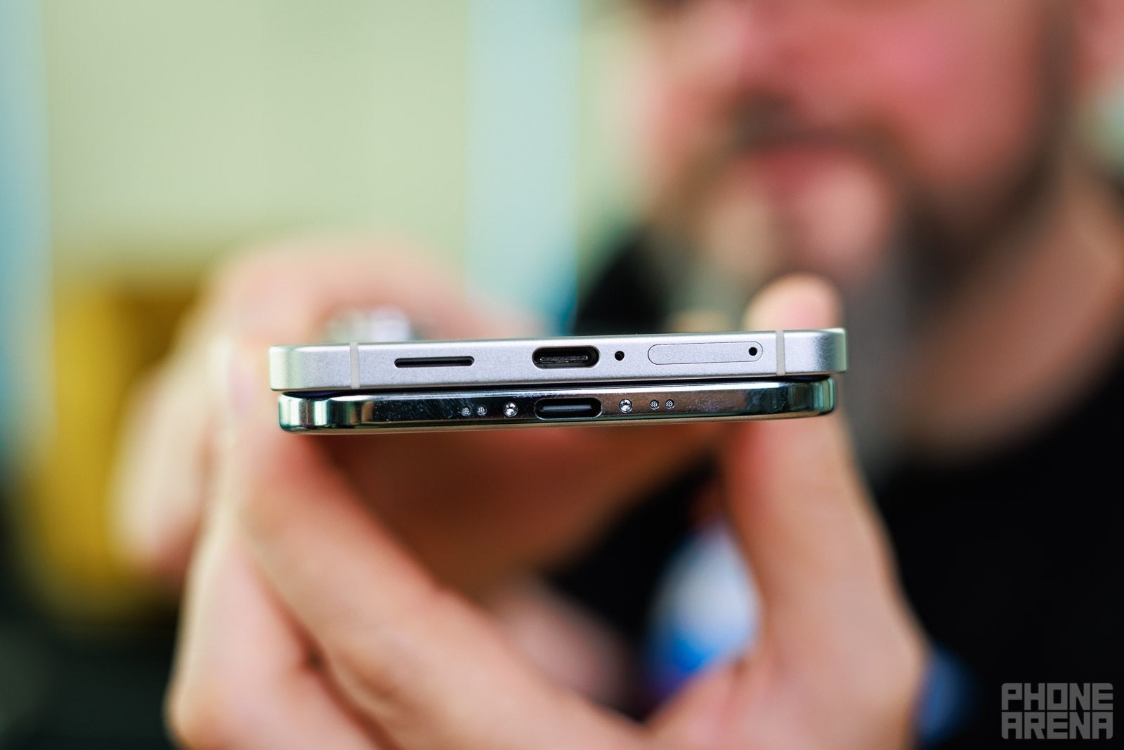 Close-up view of the bottom edges of two smartphones stacked together.