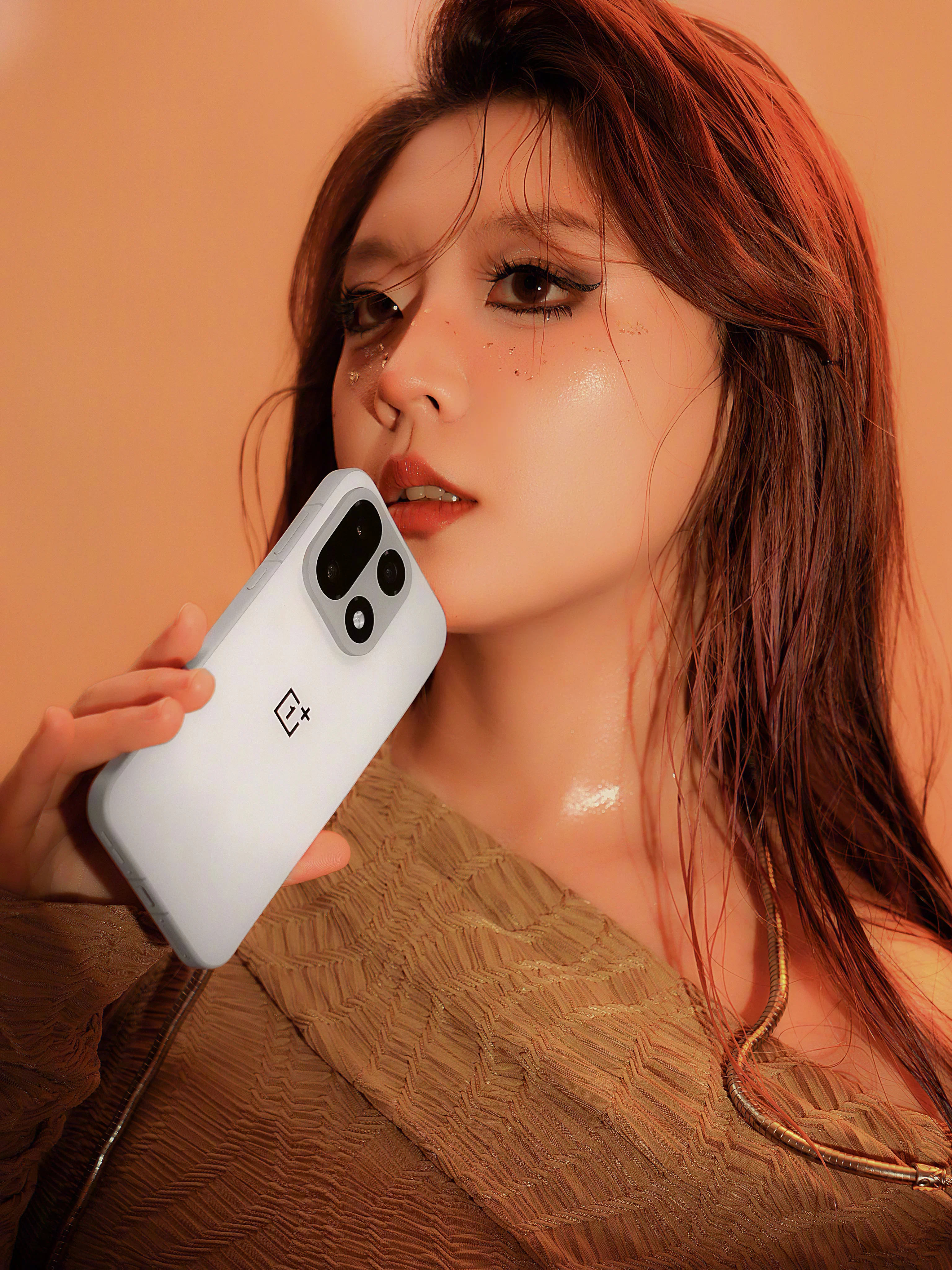 A girl wondering if she could take a bite out of the OnePlus 15.