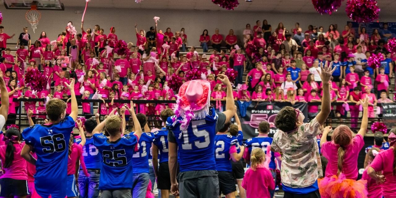 High school football players in front of an audience.