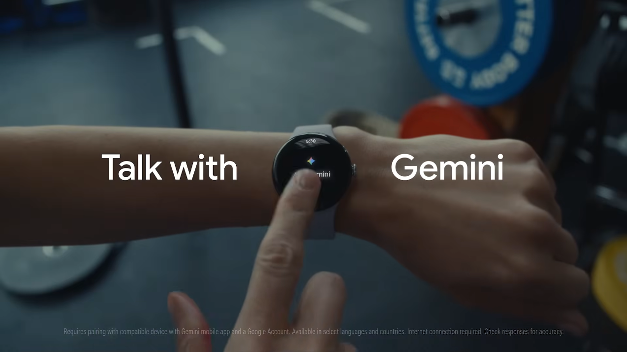 Person using a smartwatch showing the Gemini assistant interface with the text &amp;quot;Talk with Gemini&amp;quot; on screen.