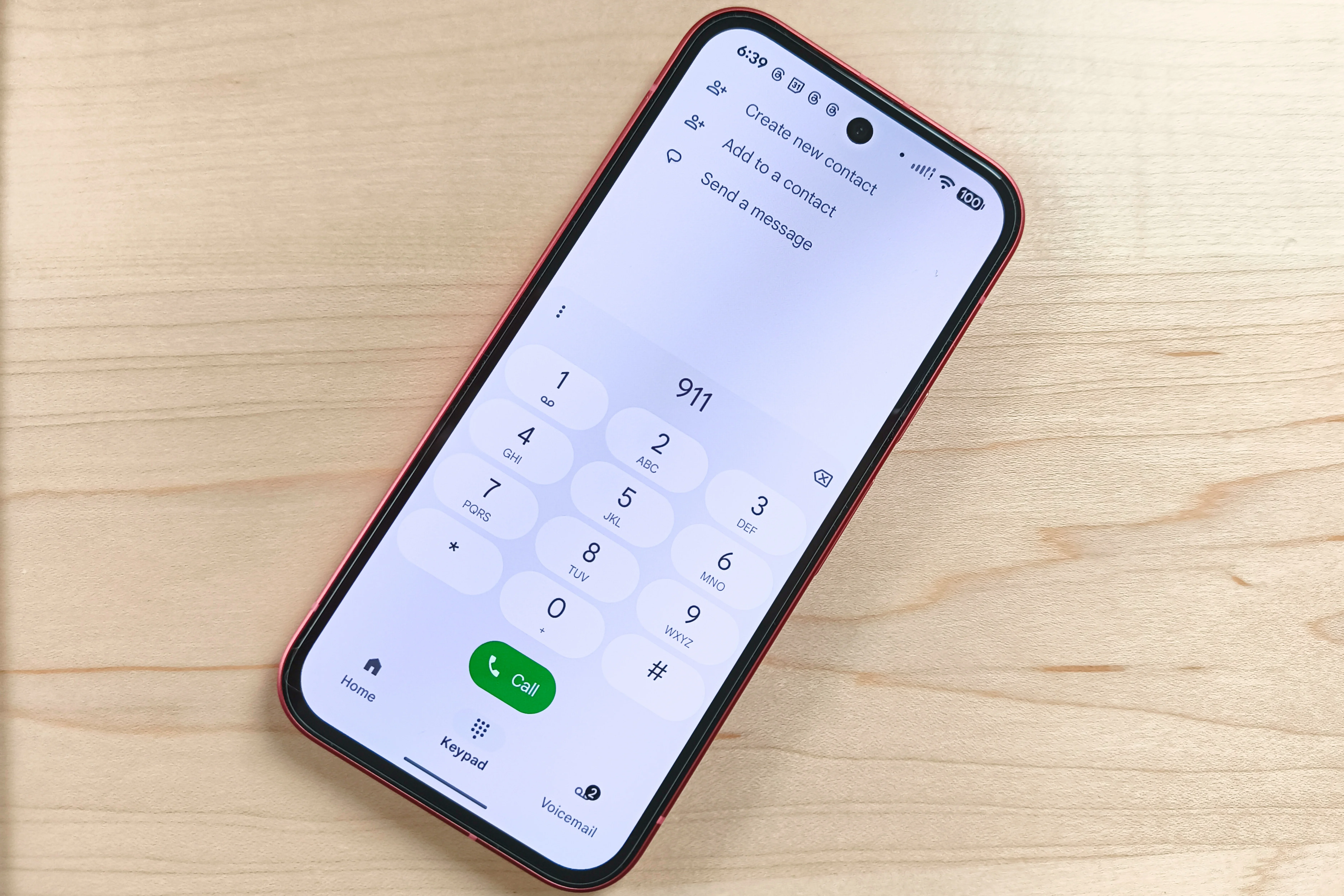 A red-framed smartphone displaying the Google Pixel Phone app dialer screen with the number 911 entered.