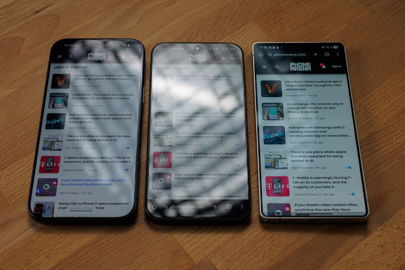 Three phones side by side showing screen glare in indoor light, screen brightness medium..